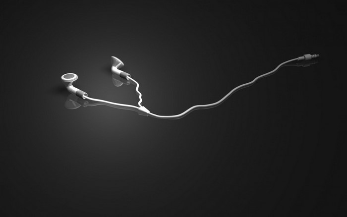 White earphones with cord on black background