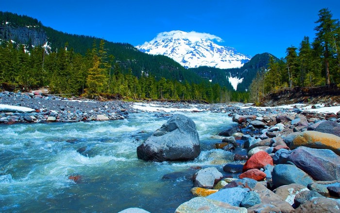 Snow-capped mountain overlooking a rocky riverbed