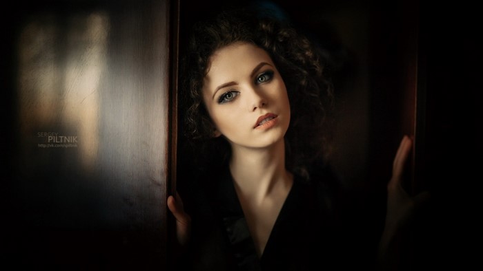 Woman with curly hair in dark setting