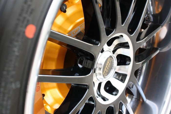 Close-up of a custom car wheel with orange brake calipers
