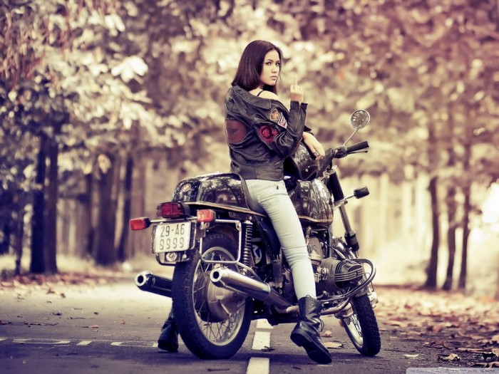 Woman on a motorcycle giving the middle finger