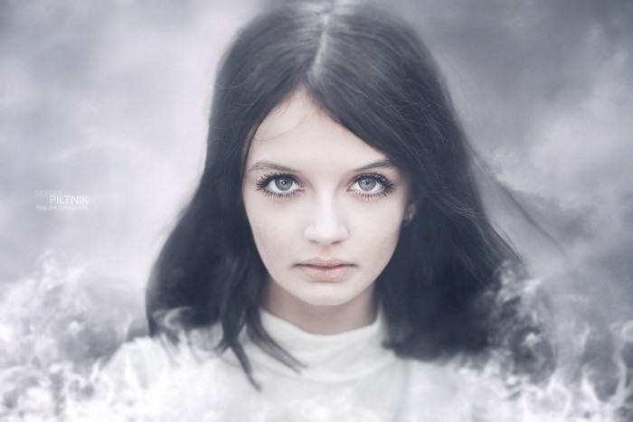 Portrait of a young woman with dark hair and striking eyes