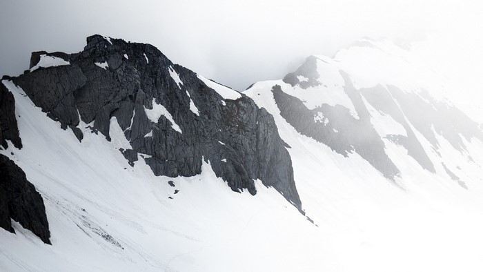 Snow-covered mountains with dark rock formations