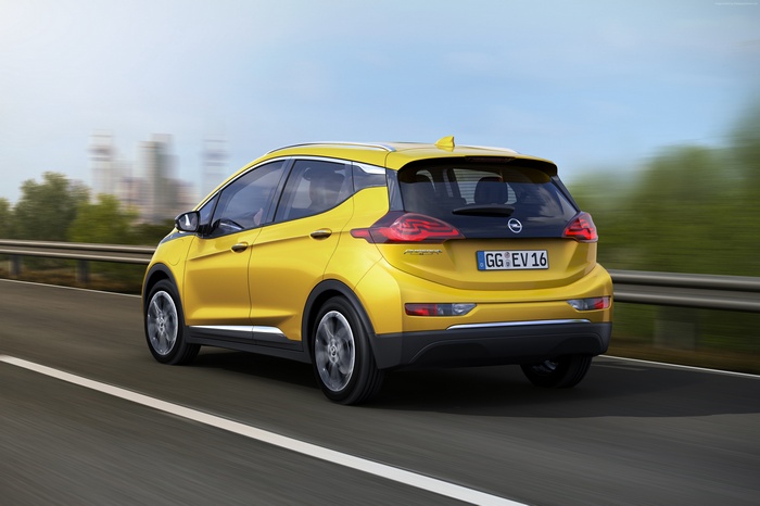 Yellow Opel Ampera-e driving on a road