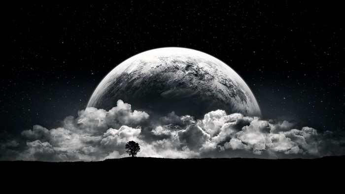 Planet rising over clouds with a lone tree