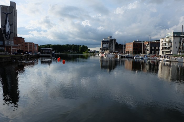 Cityscape with harbor, boats, and reflections on water