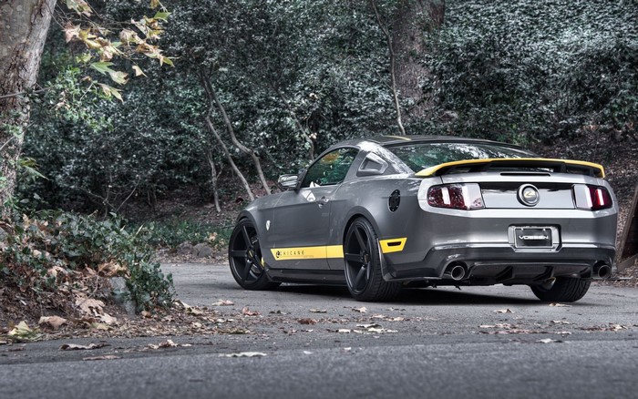 Gray Ford Mustang with yellow accents parked on a road