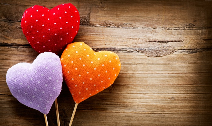 Three polka dot hearts on wooden background