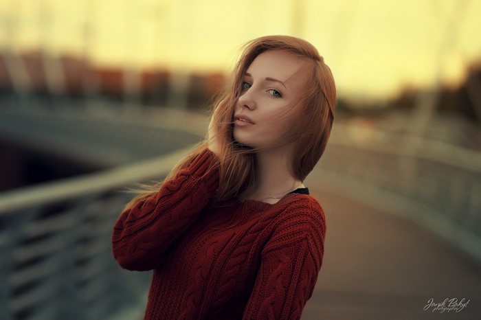 Redhead woman in a red sweater posing outdoors