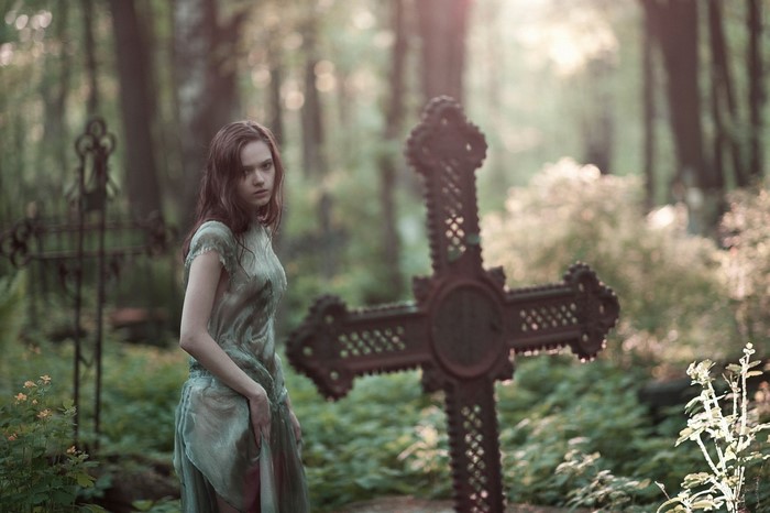 Woman in a dress in a graveyard with crosses