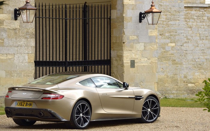 Aston Martin Vanquish parked in front of a stone building