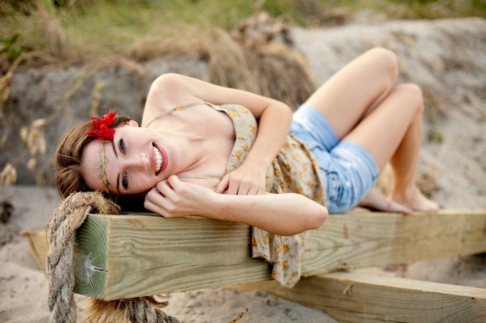 Smiling Woman Relaxing on Beach Wood Beam