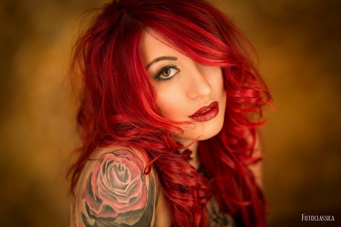 Woman with red dyed hair and rose tattoo
