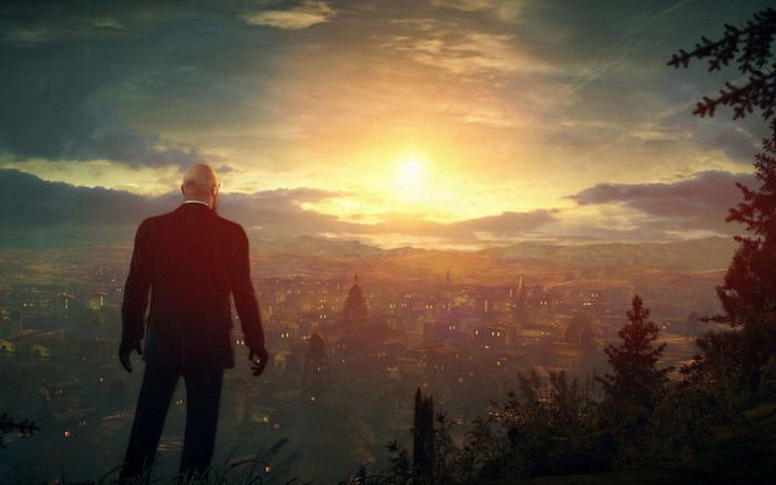 Agent 47 from Hitman overlooking a city at sunset