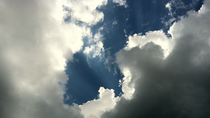 Sunlight breaking through dark clouds in the sky