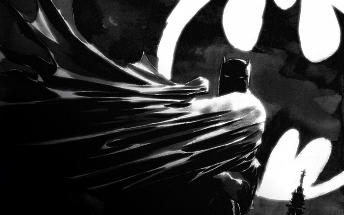 Batman in front of a large bat symbol