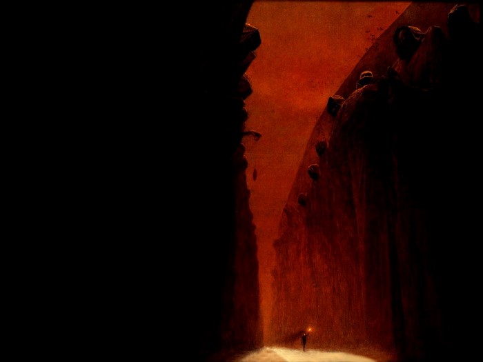A lone figure with a lantern in a dark, rocky canyon