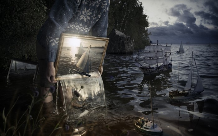 Man holding a picture frame with a sailboat scene