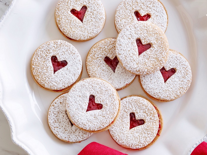 Heart-shaped jam cookies dusted with powdered sugar