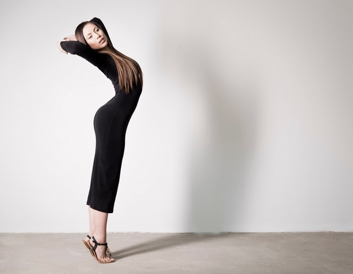 Woman in black dress posing with arched back