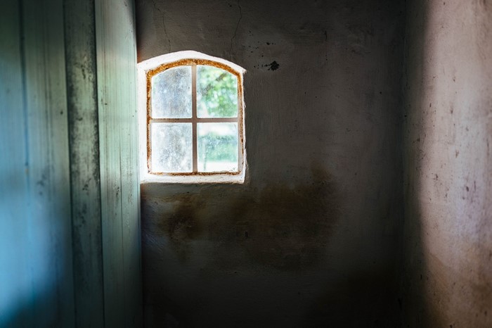 Small window in a dark room with blue door