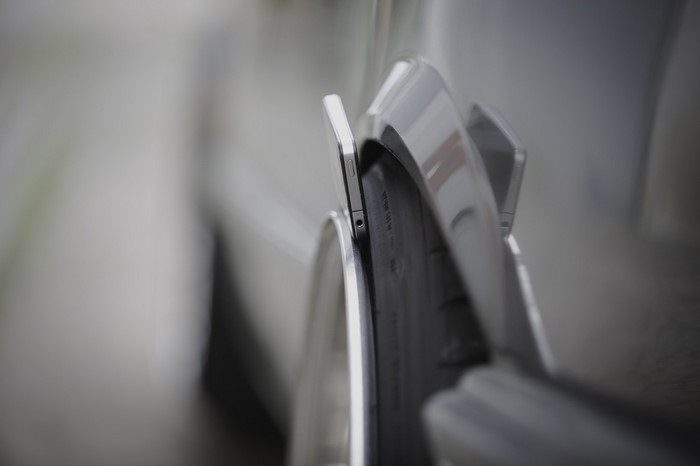 iPhone placed on a car tire and fender
