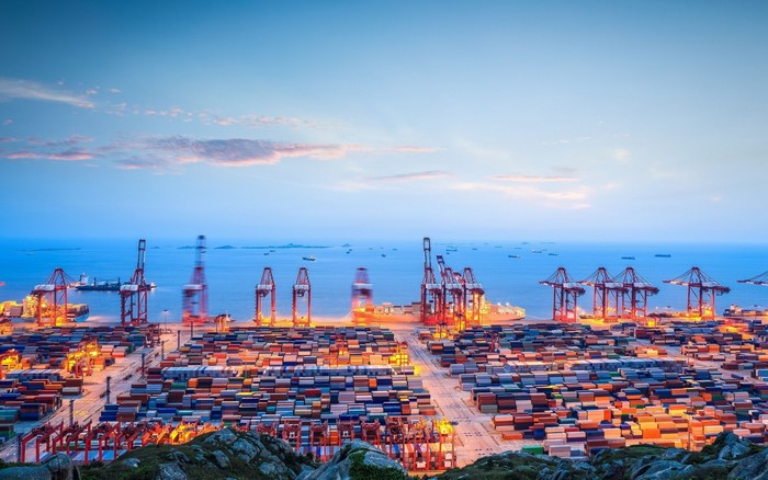 Container port with cranes and ships at dusk