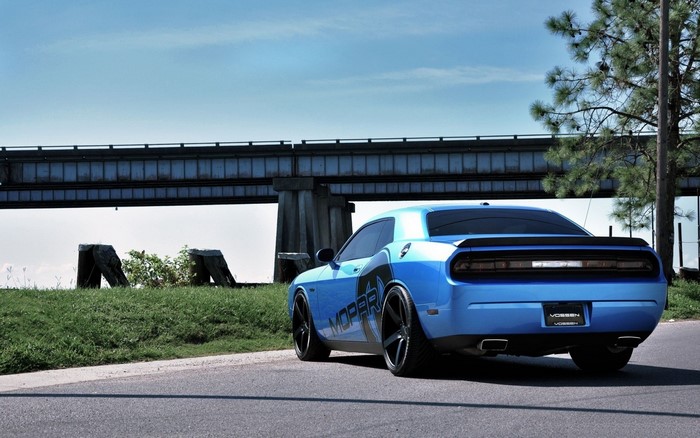 Blue Dodge Challenger with Mopar graphics on road under bridge