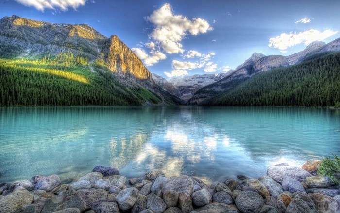 Turquoise lake reflecting mountains and forest