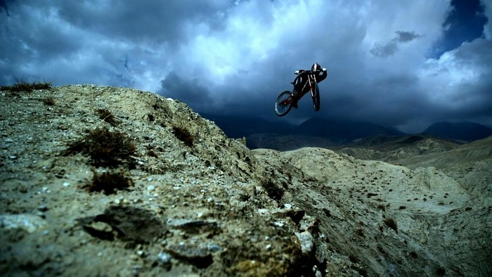 Mountain biker jumps over a rocky terrain