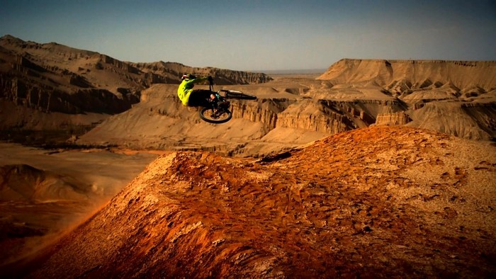 Mountain biker performing a trick in a desert landscape