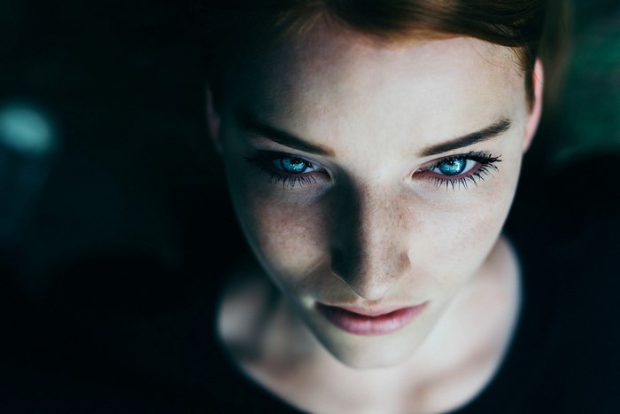 Close up portrait of a woman with blue eyes and freckles