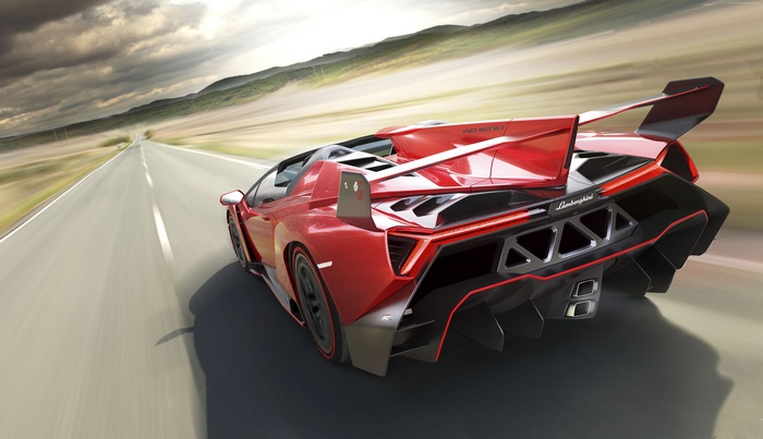 Red Lamborghini Veneno driving on a road