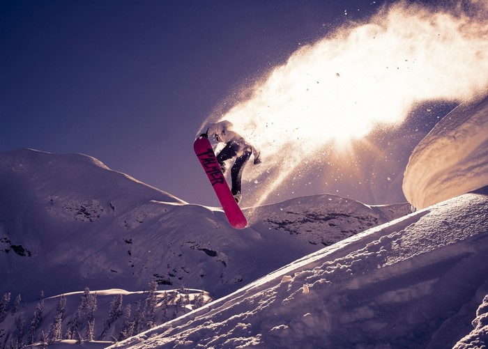 Snowboarder jumping in the air with snow spray