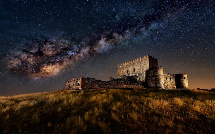 Castle ruins under the Milky Way at night
