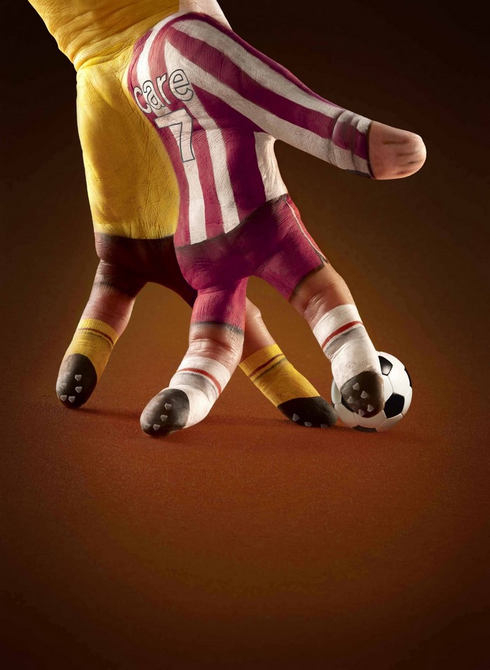 Hands painted as soccer players with a soccer ball