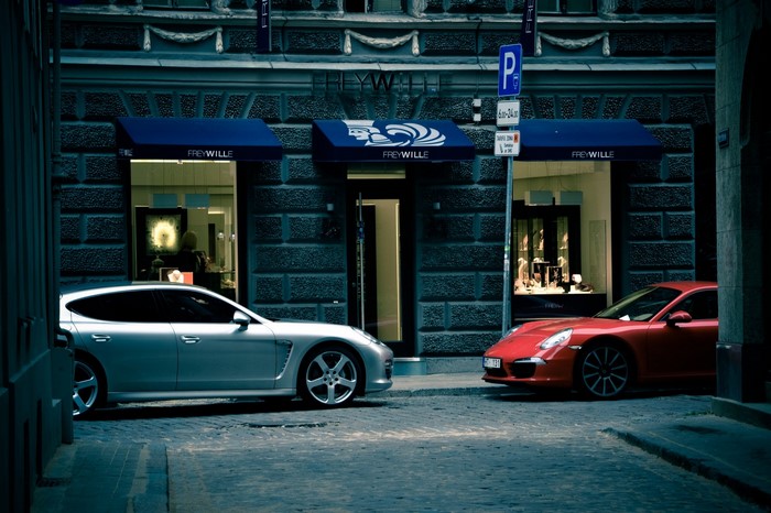 Two luxury sports cars parked outside a FreyWille store