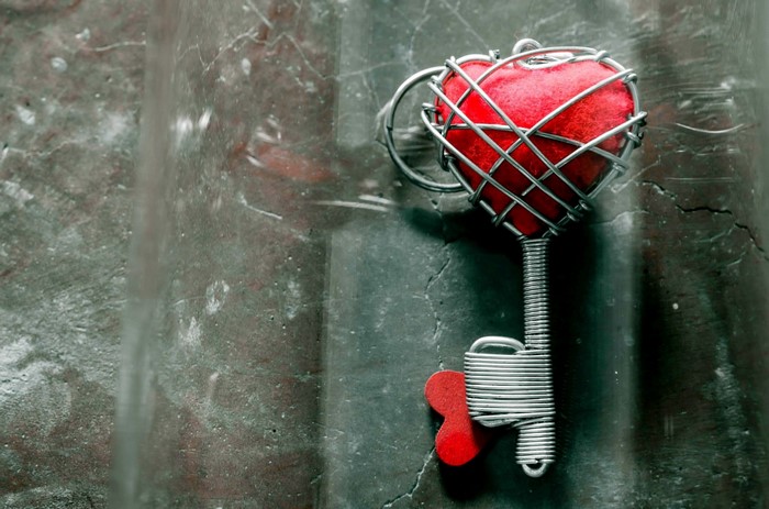 Red heart key on a textured surface