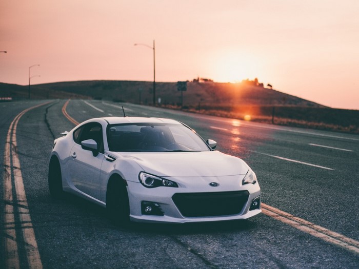 White Subaru BRZ on a road at sunset