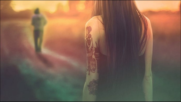 Woman with tattoos and a person walking away
