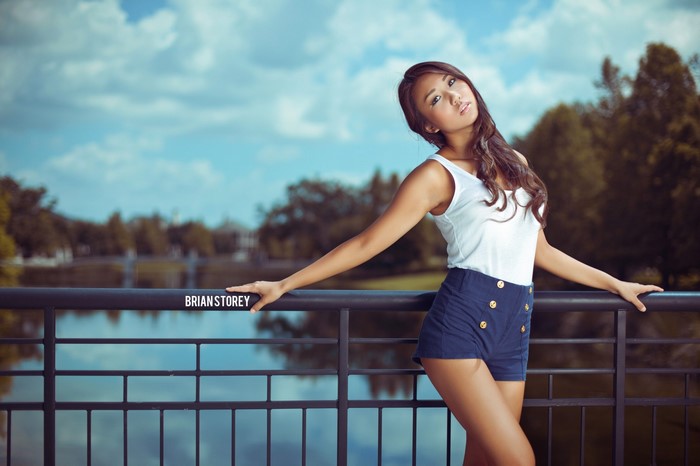 Elegant Woman Leaning on Railing by the Lake