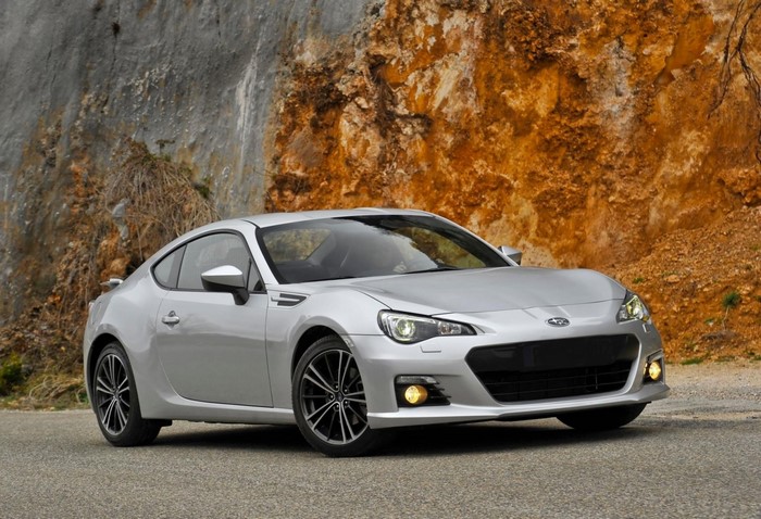 Silver Subaru BRZ Coupe parked on a road with rocky cliff background