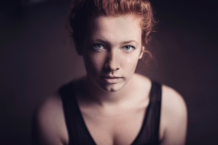 Portrait of a young woman with auburn hair and freckles