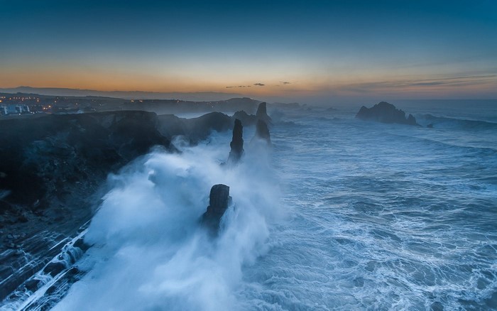 Waves crashing on rocky coast at sunset