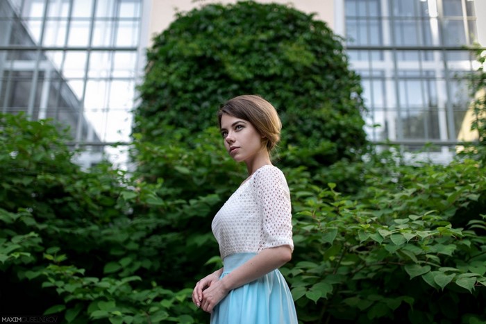 Woman in white top and blue skirt in garden