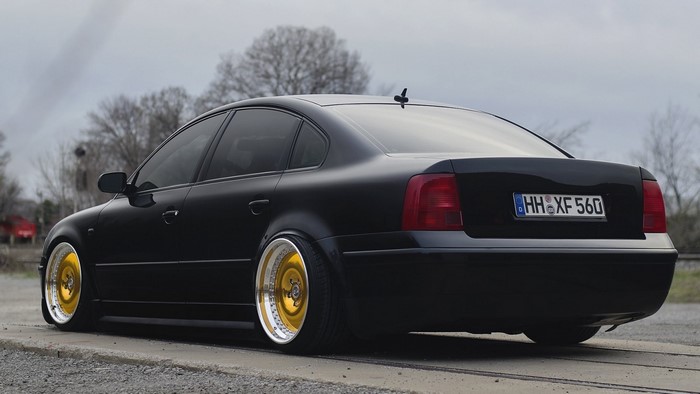 Black Volkswagen Passat with gold wheels