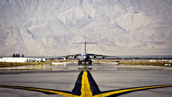 Boeing C-17 Globemaster III on a runway with mountains