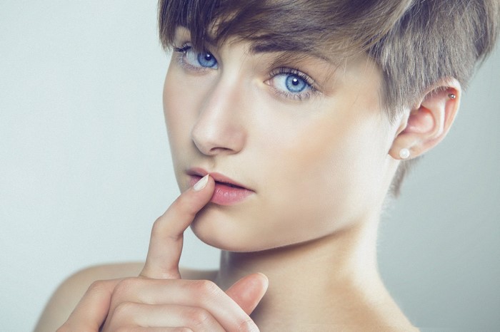 Close-up portrait of a woman with blue eyes and short brown hair