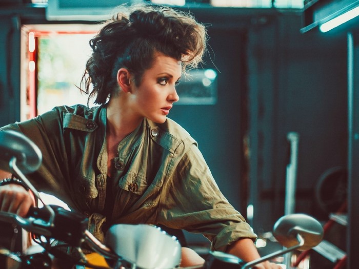 Woman with mohawk sitting on a motorcycle