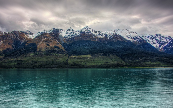 Snow-capped mountains over a turquoise lake